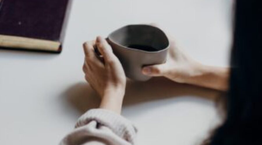 Two people sat talking at a table over a cup of coffee